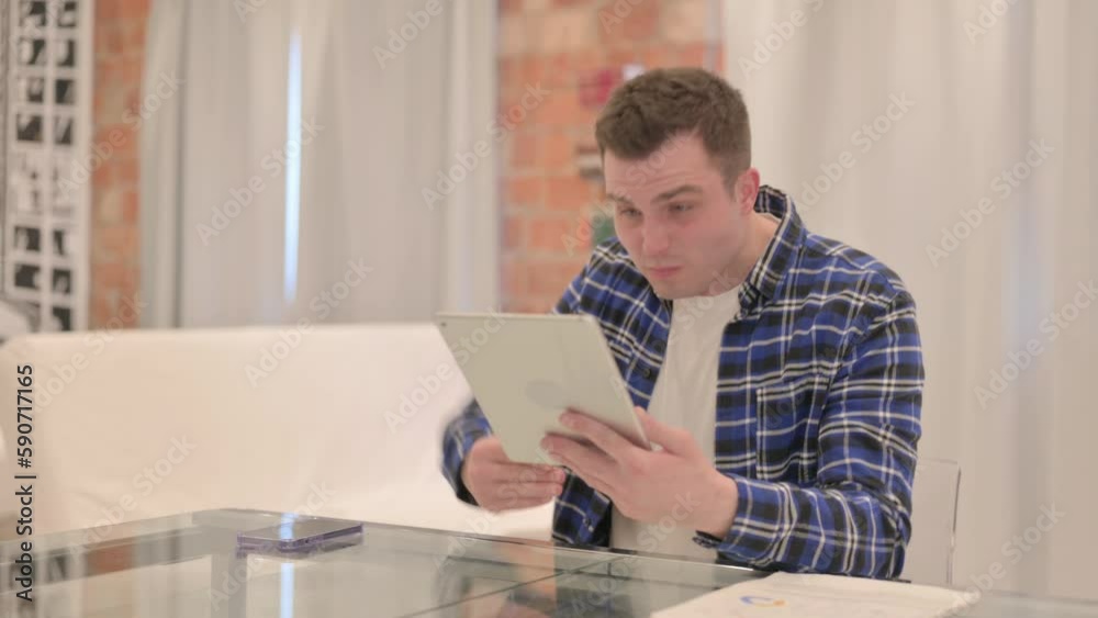 Young Casual Man Upset by Loss on Tablet Young Casual Man Upset by Loss on Tablet