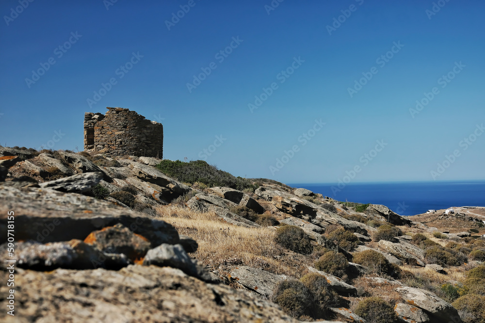 View of an old and abandoned windmill overlooking the Aegean Sea in Ios Greece
