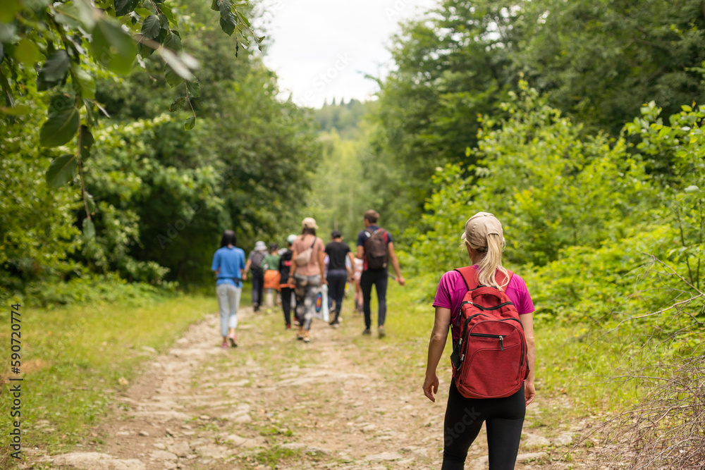 Fototapeta premium Group of hikers with backpacks climbing up mountains