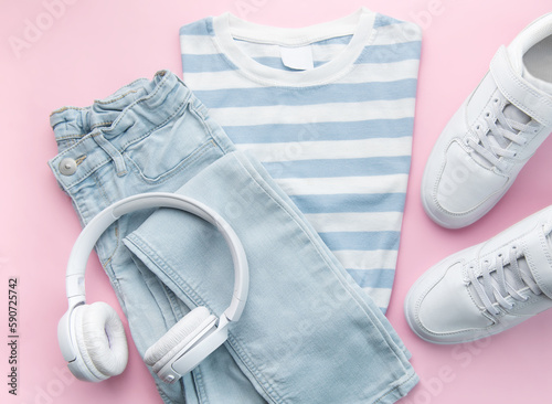 Child's t-shirt, shoes and headphones on blue backgrund