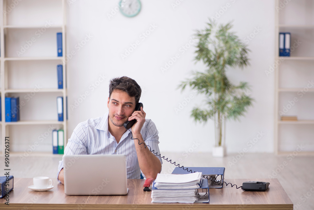 Young male employee working in the office Young male employee working in the office