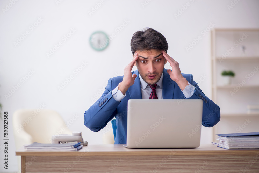 Young male employee working in the office Young male employee working in the office