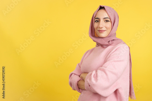 Muslim woman standing with arms crossed looking at camera © Iván Moreno