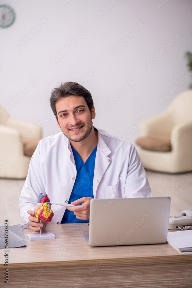 Young male doctor cardiologist sitting at the hospital Young male doctor cardiologist sitting at the hospital