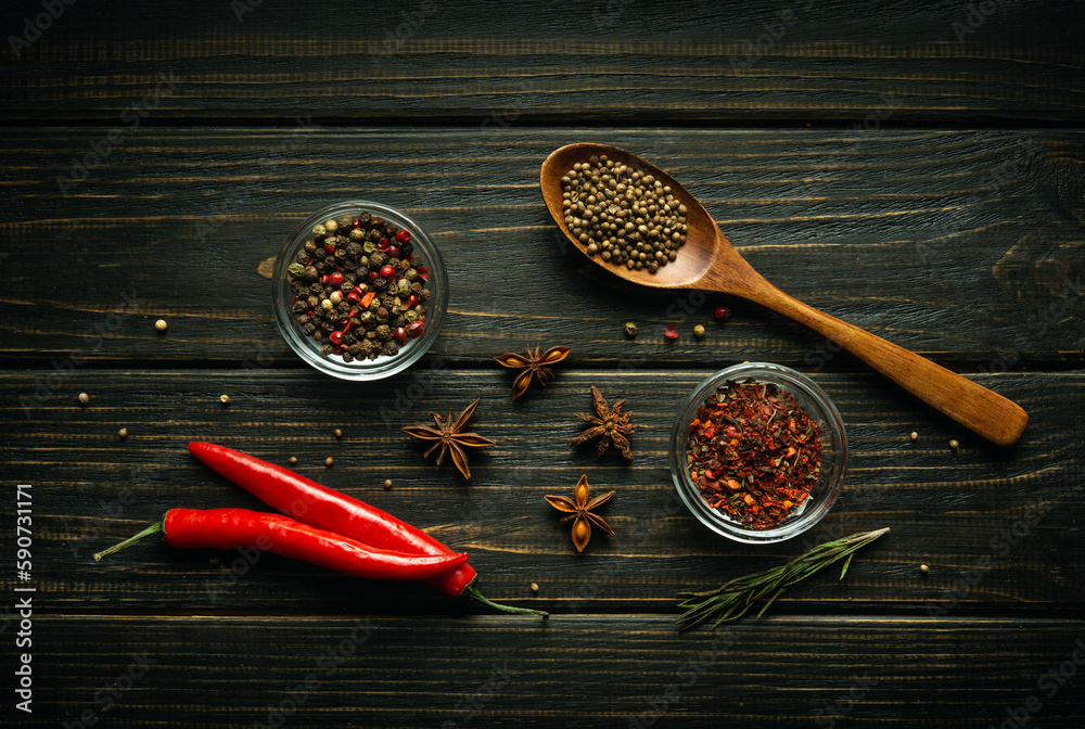 Pods of red chili peppers and dry spices with coriander in a spoon on a black vintage table prepared for adding to food. Free space for menu or recipe Pods of red chili peppers and dry spices with coriander in a spoon on a black vintage table prepared for adding to food. Free space for menu or recipe