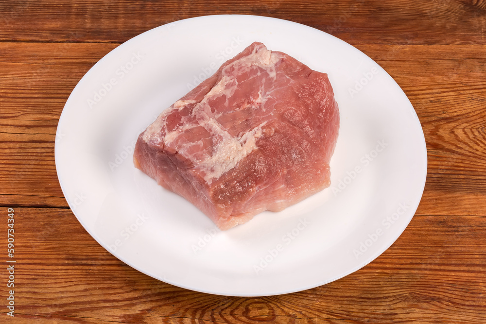 Piece of raw pork from the hind leg on dish Piece of raw pork from the hind leg on dish