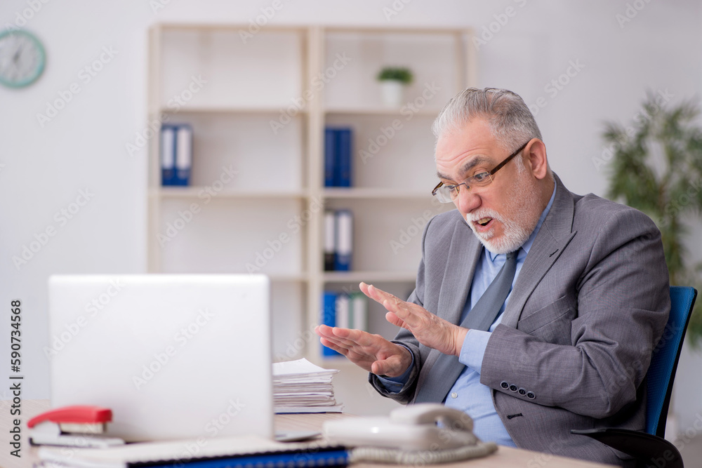 Old male employee working in the office Old male employee working in the office