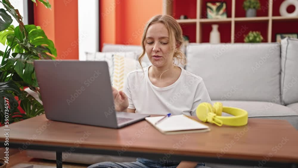 Young blonde woman having online class sitting on floor at home Young blonde woman having online class sitting on floor at home