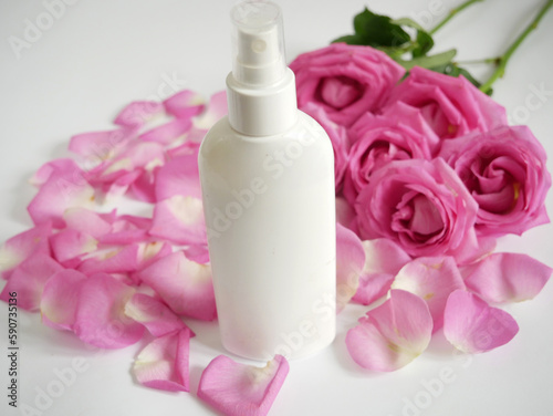 Luxury cosmetic cream ad, cream product tube with roses and petals on white background.