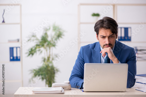 Young male employee and too much work in the office