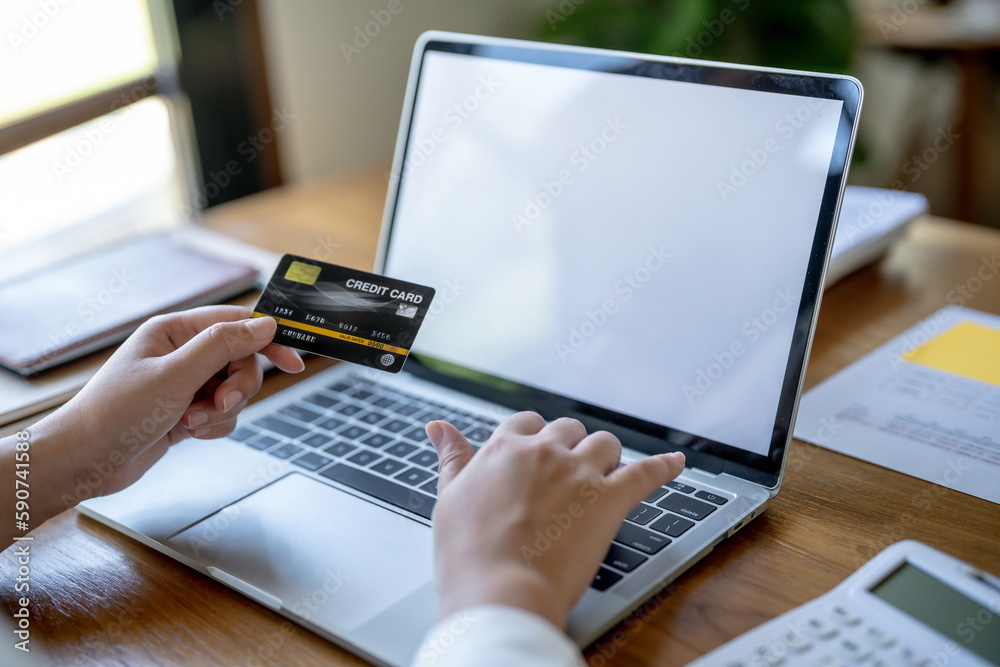 Woman shopping on laptop holding credit card for Internet online e-commerce shopping spending money Online shopping Mobile phone laptop technology concept