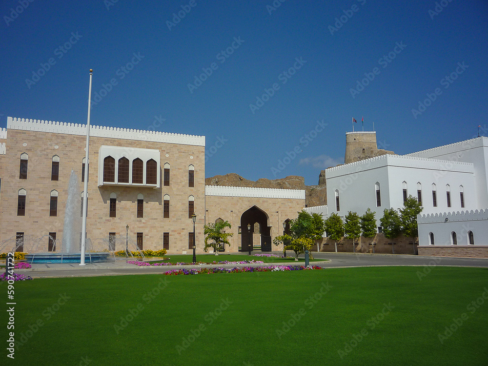 Medieval historic old house facades and stone building ancient town city skyline with palace, palm trees and small alleys in Muscat, Oman city center downtown with flower parks 1001 Arabian Nights