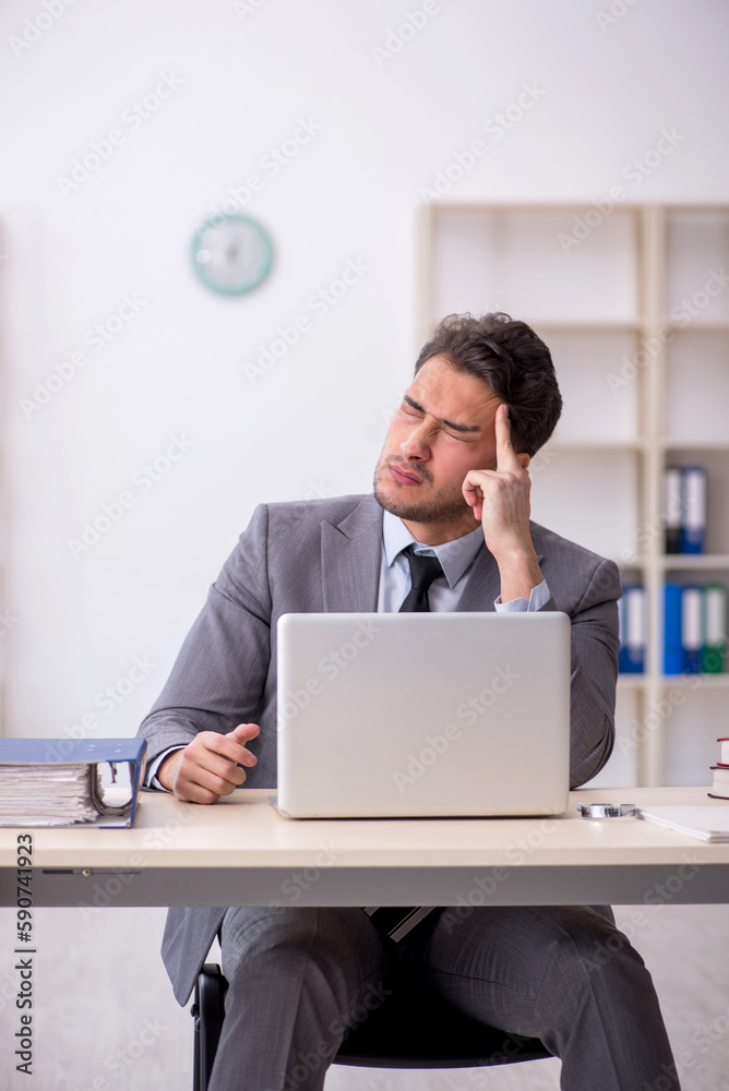 Young male employee working in the office Young male employee working in the office