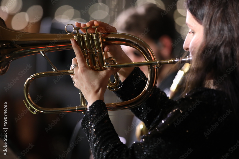 Obraz premium Flugelhorn in the hand of a musician playing a close-up view of a golden musical instrument