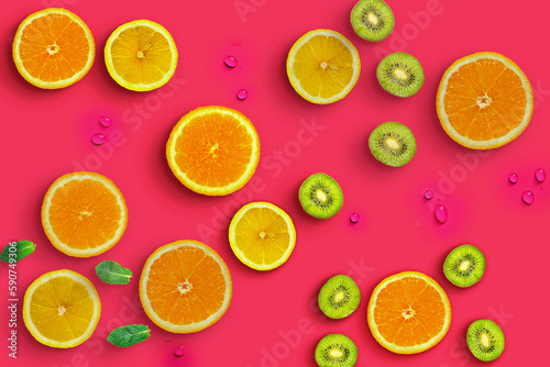 Fresh juicy slices of orange  kiwi fruit and lemon on bright red background covered with water drops. Creative food background  top view