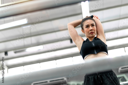 boxing woman bending body wearing gloves on fighting ring. calm muscular gym coach stretching body before exercise boxing training activity. relax slim female athlete bend arms and hands warm body