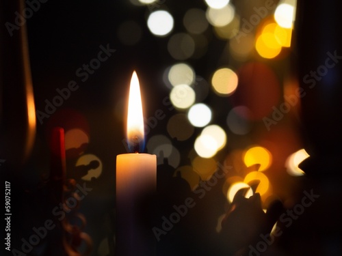 Closeup shot of a burning candle on a glowing bokeh background