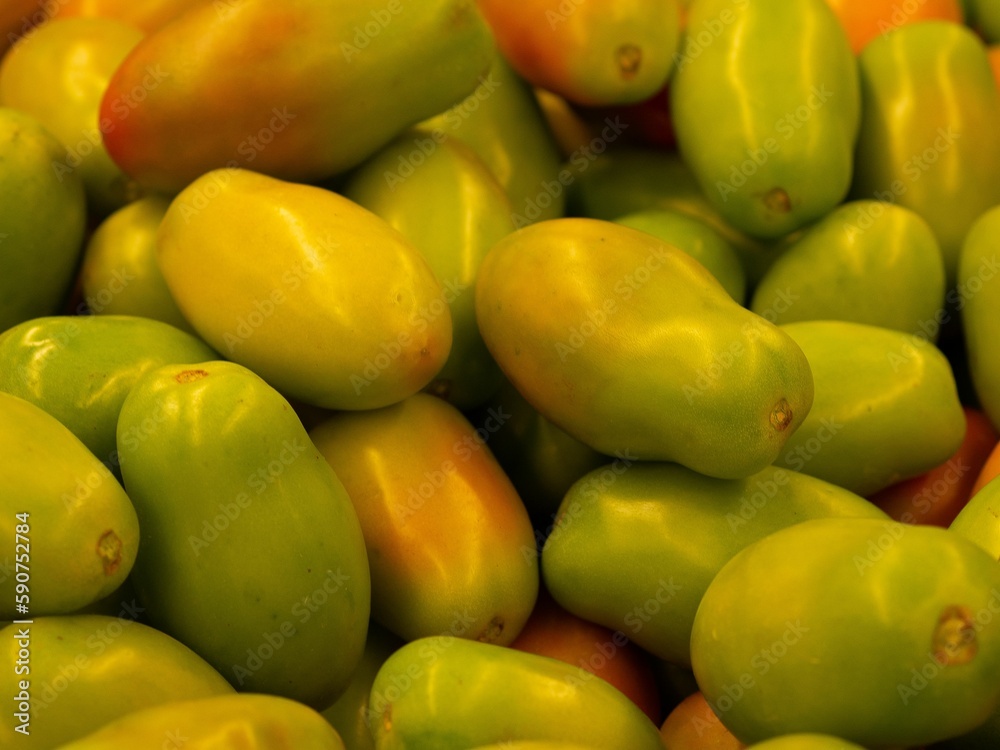 Closeup shot of a pile of yellow bell tomatoes found in the marketplace Closeup shot of a pile of yellow bell tomatoes found in the marketplace