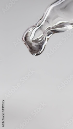 a drop of oil falls from a pipette on a white background, slow motion