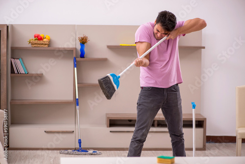 Young male contractor cleaning the house © Elnur