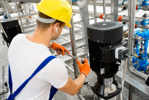 A young factory worker installs water purification equipment. © Olha