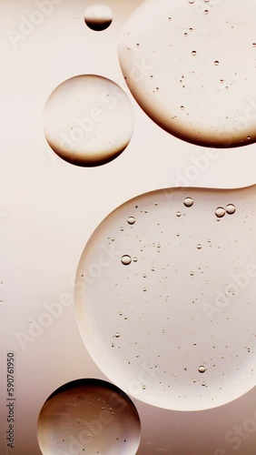 a drop of oil connects with another drop, golden background