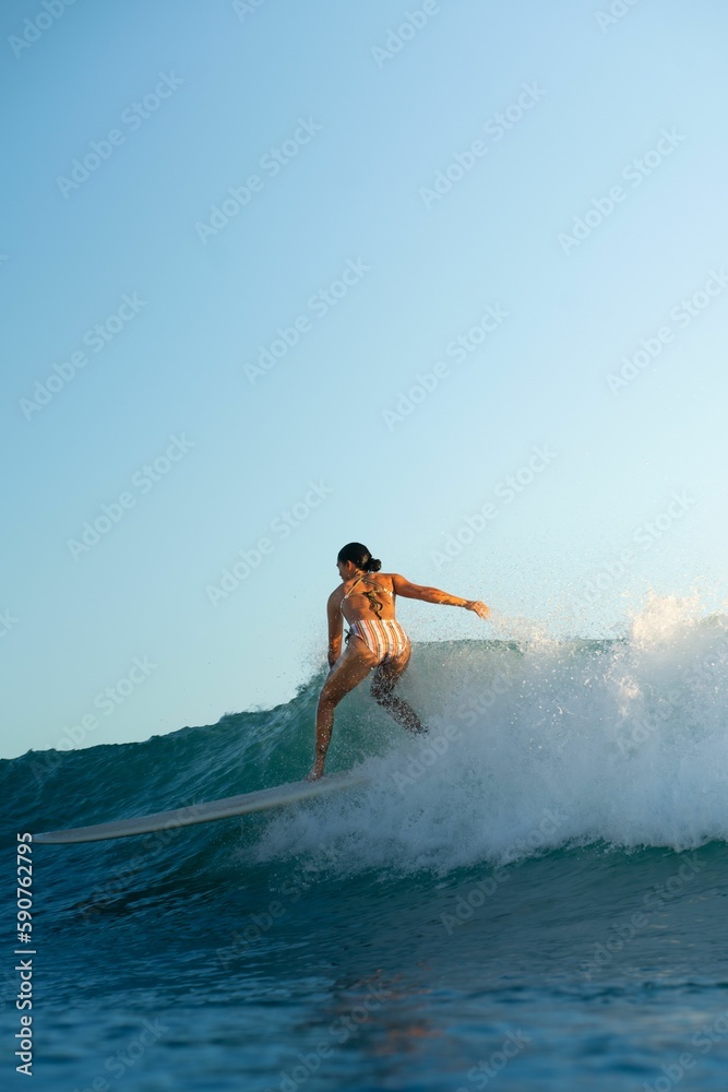 Fototapeta premium Person surfing in the ocean on a sunny day