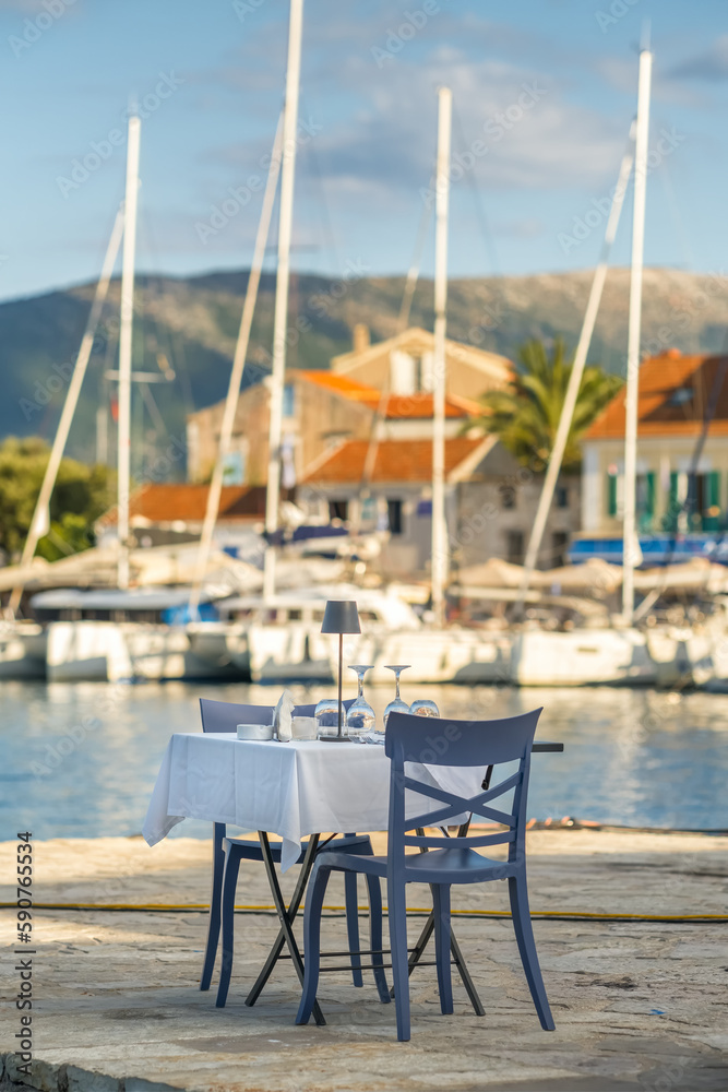 Table in a cafe with a tablecloth, empty glasses and plates on the seashore