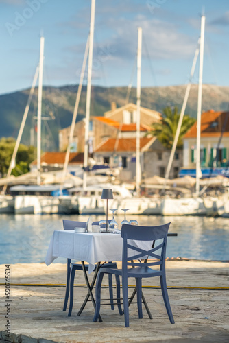 Table in a cafe with a tablecloth, empty glasses and plates on the seashore © Mazur Travel