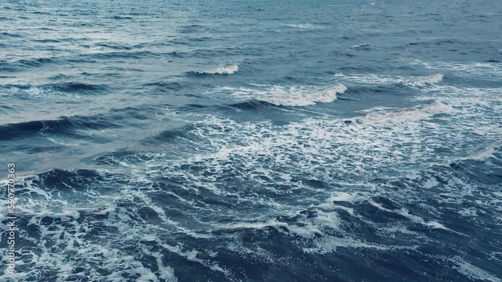 Evening aerial view of seagulls hovering over the ocean surf. Ocean landscape with rolling waves covered with sea foam. Evening aerial view of seagulls hovering over the ocean surf. Ocean landscape with rolling waves covered with sea foam.