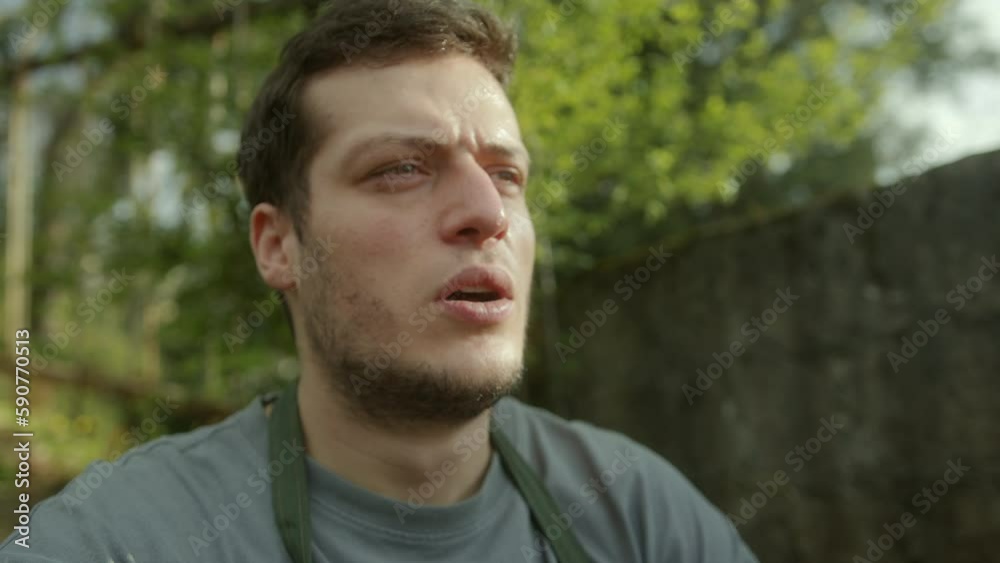 Young handsome farmer resting and catching his breath while sitting on the side after working hard outside Young handsome farmer resting and catching his breath while sitting on the side after working hard outside