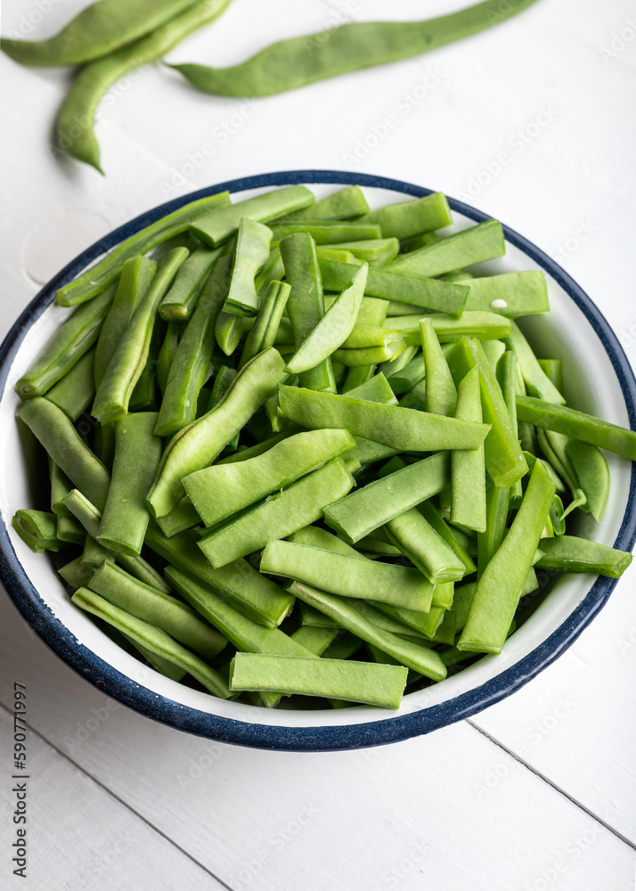 Fresh green beans in a bowl on a white wooden table. Bowl of green beans on wooden background. Fresh green beans in a bowl on a white wooden table. Bowl of green beans on wooden background.