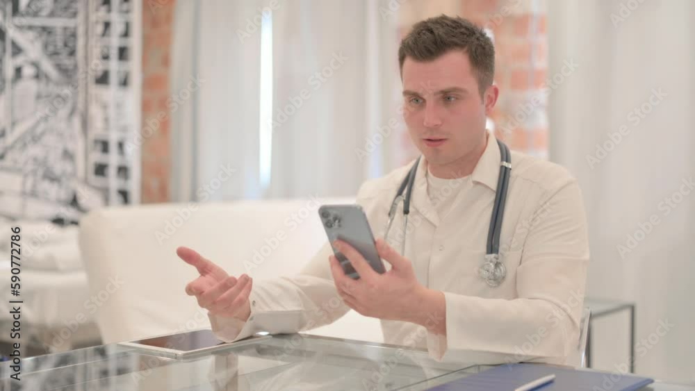 Online Video Chat via Smartphone by Male Doctor in Clinic Online Video Chat via Smartphone by Male Doctor in Clinic