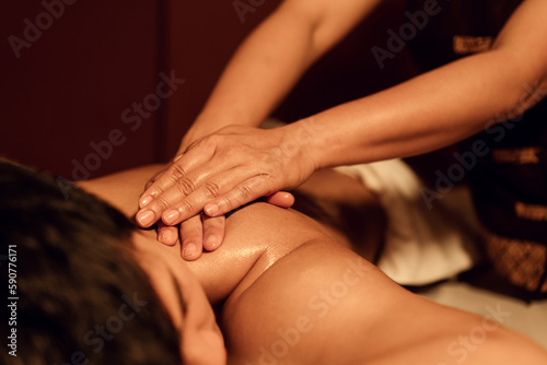 Masseuse hand massage aroma on back a man customer in cosmetology spa centre.