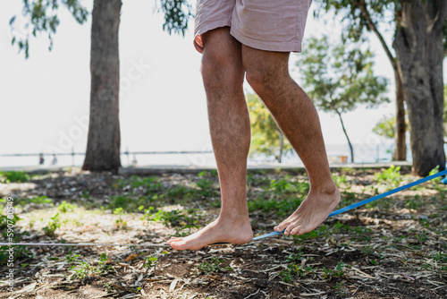 Male feet on slackline during slacklining in city park
