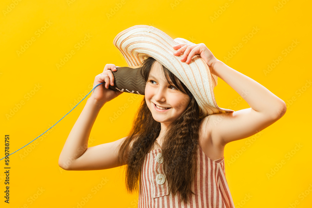 A little pretty girl playing with a handmade toy phone with a paper cup and thread. Communication technology concept. Information transfer concept. A little pretty girl playing with a handmade toy phone with a paper cup and thread. Communication technology concept. Information transfer concept.
