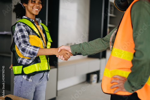 Engineer and contractor join hands after signing contract,They are having a modern building project together. successful cooperation concept..