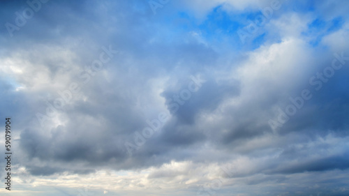 Fototapeta Naklejka Na Ścianę i Meble -  Dramatic sky with dark cumulus clouds. Menacing heavy clouds in the blue sky
