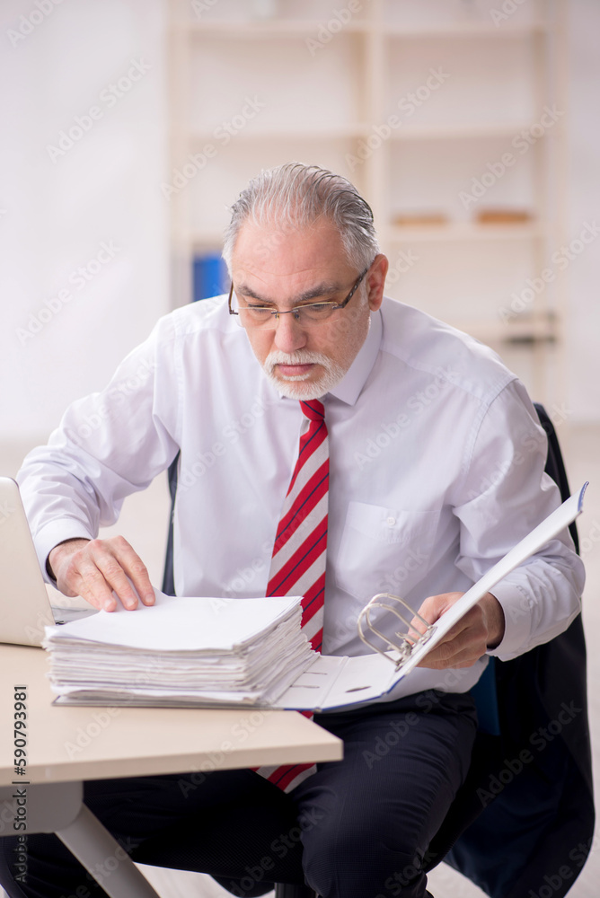 Old male employee and too much work at workplace Old male employee and too much work at workplace