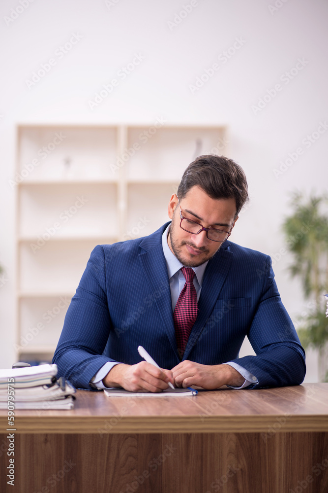 Young male employee and too much work in the office Young male employee and too much work in the office