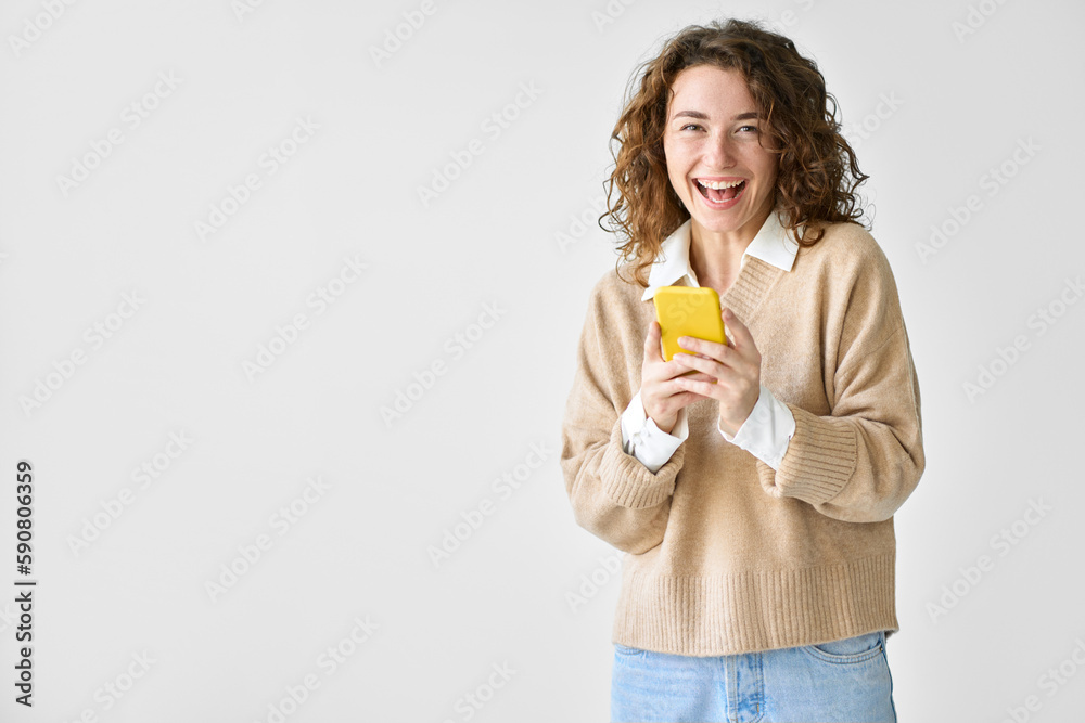 Happy young woman holding smartphone standing isolated at white background using mobile cell phone, excited about ecommerce shopping online, texting messages on cellphone, advertising apps. Happy young woman holding smartphone standing isolated at white background using mobile cell phone, excited about ecommerce shopping online, texting messages on cellphone, advertising apps.
