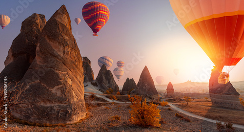 Landscape Valley of Love in Cappadocia with set colorful hot air balloon fly in sky with sun light. Concept banner tourist travel Goreme Turkey