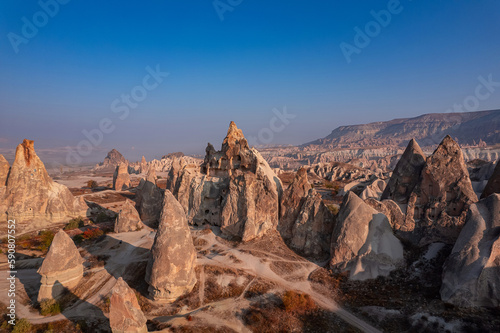 Closeup ancient Goreme cave in big stone, hot air balloons fly over deep canyons, valleys Cappadocia National Park with sunlight, Turkey Travel © Parilov