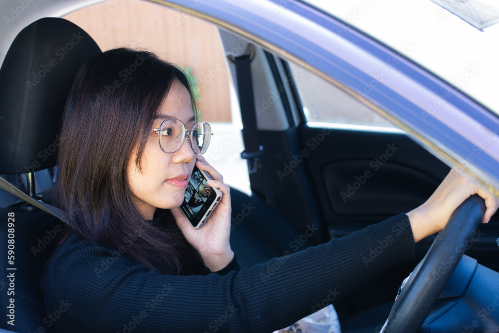 Woman in black talking on the phone while driving