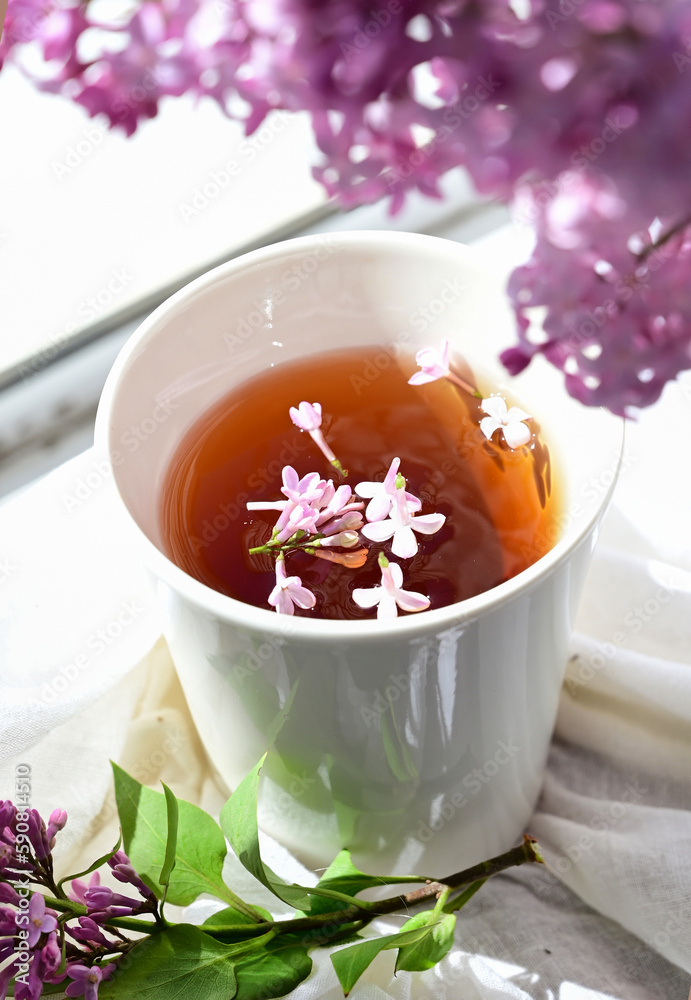 The postcard is beautiful. A mug of tea, an old book and a bouquet of purple lilac. A beautiful still life. Spring time. The concept of Good morning. The postcard is beautiful. A mug of tea, an old book and a bouquet of purple lilac. A beautiful still life. Spring time. The concept of Good morning.