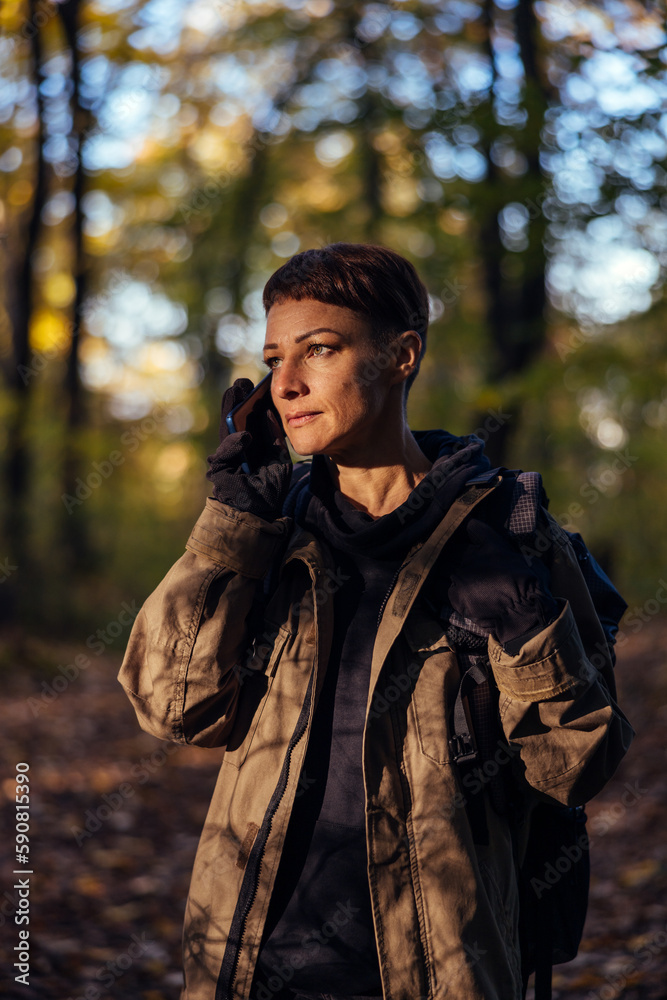 Obraz premium a person using a phone in the woods