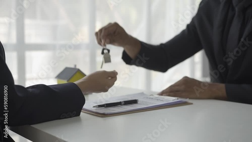 Real estate brokers present and advise clients on the decision to sign insurance contracts. Buy and sell a house Loan offer with office handshake