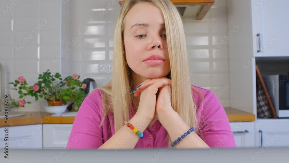 Young woman with scarred face and prosthetic eye thinking about problem solution on a computer Young woman with scarred face and prosthetic eye thinking about problem solution on a computer