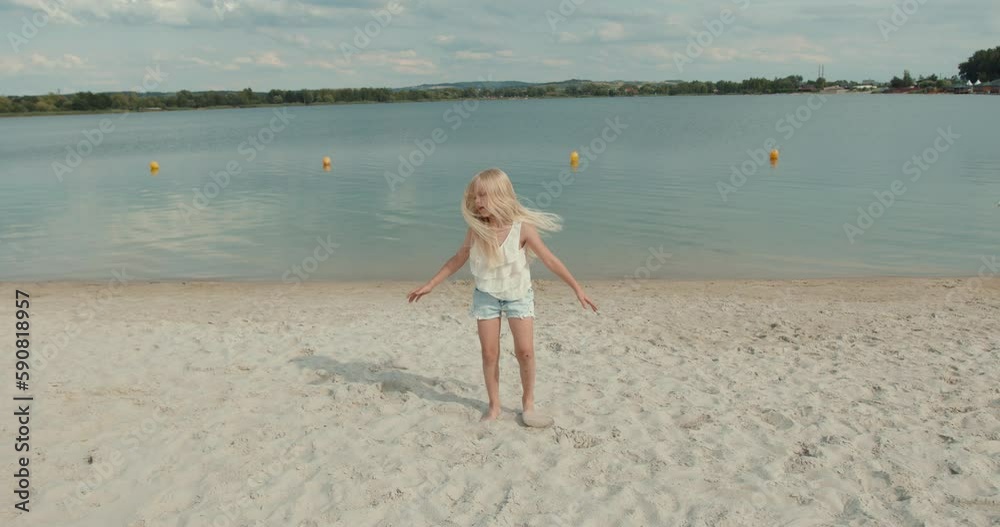 Charming little girl doing stretching exercises on the beach Charming little girl doing stretching exercises on the beach