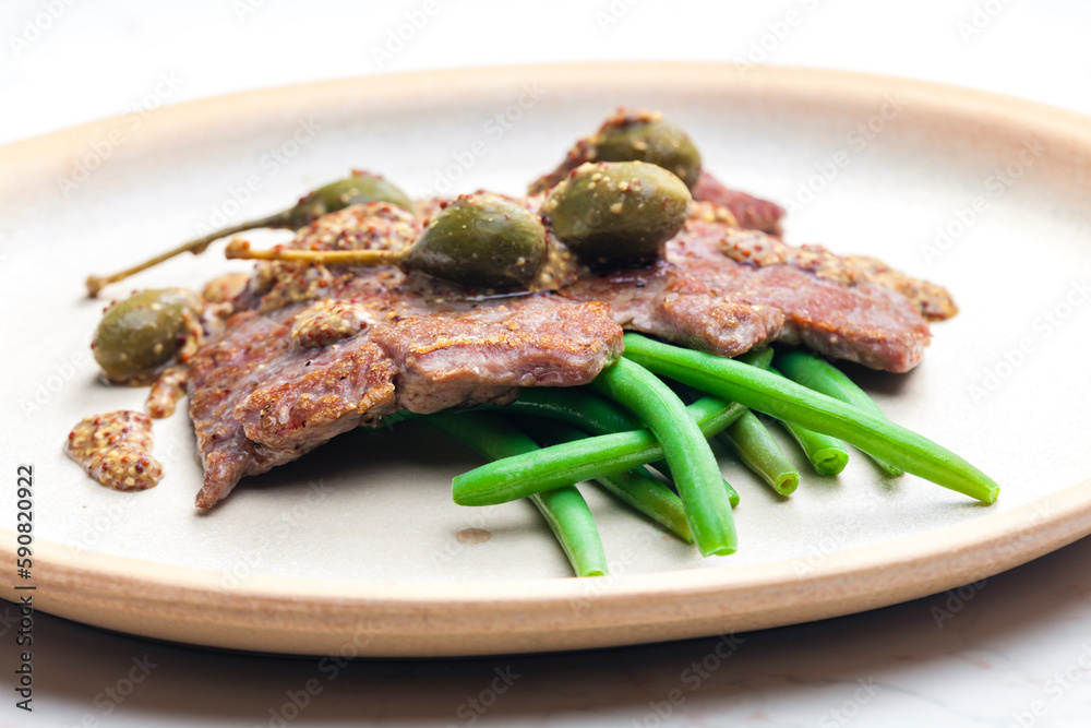 pork steak with mustard sauce with capers served with green beans